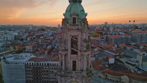 Alter Glockenturm mit Drohne vor atemberaubendem Abendpanorama, Stadtlandschaft bei Sonnenuntergang