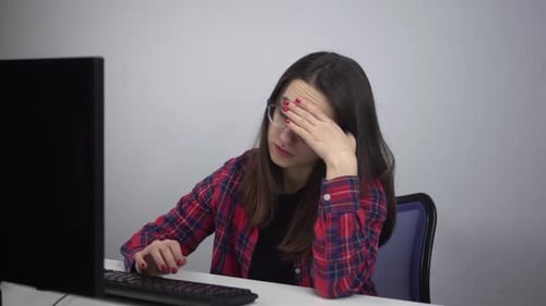 Un informaticien est assis lassement au bureau devant un ordinateur