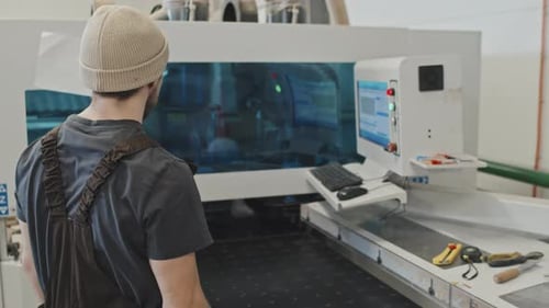 Man Working with Modern Equipment at Furniture Factory