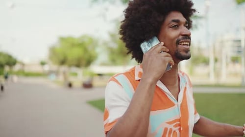 man walking and talking on smartphone on path in the park