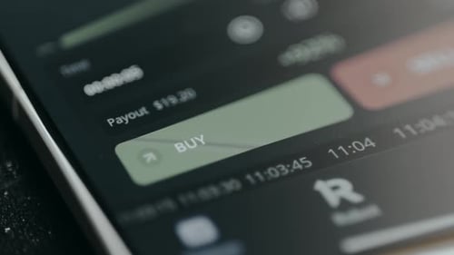 Finger Taps Buy Button on Mobile Trading App
