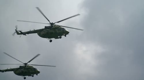 Military helicopters flying through the sky on cloudy day
