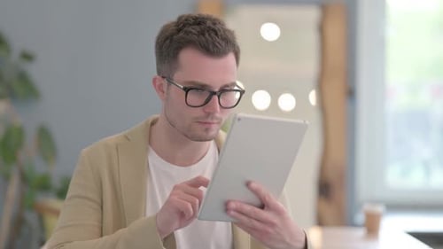 Young Man Using Tablet Receives Good News