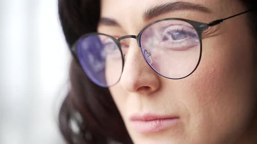 Close up portrait of woman wearing glasses, demonstrating focus and determination. Her expression
