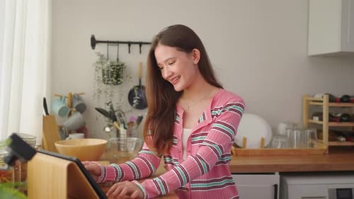 Woman Using Tablet in Bright Kitchen