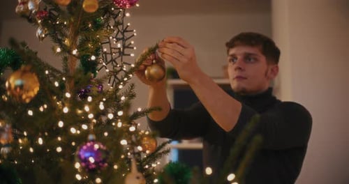 Man Decorating Christmas Tree at Home