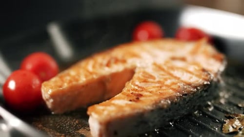 A Salmon Fillets on a Grill Plate with Herbs and Vegetables