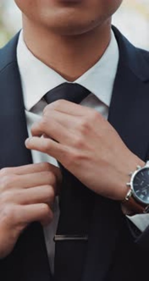Hands, wedding and tie with a man getting reading for a marriage ceremony outdoor at an event