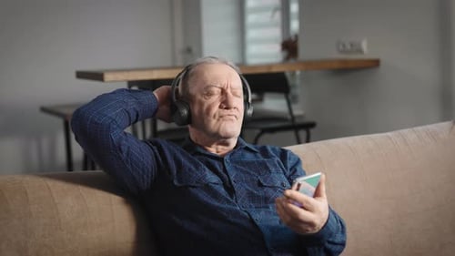 Senior Man Relaxing with Headphones and Smartphone