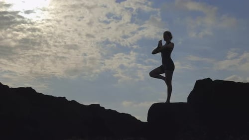 Woman Doing Yoga in Silhouette on Rocks
