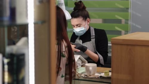 Cosmetologist giving a manicure to her client