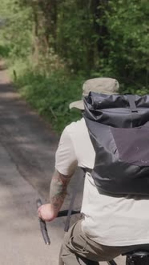 Top View of Cyclist Riding with Backpack on Forest Road