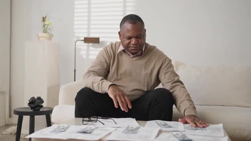 Man Counts Money, Worried About Bills at Home