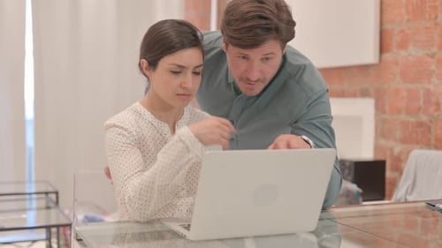 Couple Collaborating on Laptop in Bright Home Office
