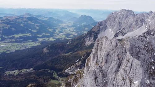 Aerial of steep rocky alpine mountain top peaks, epic landscape drone scenery view into valley