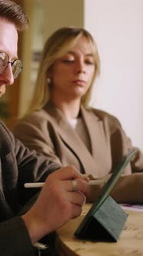 Focused Professionals Collaborating with Digital Tablet and Stylus During Modern Office Meeting