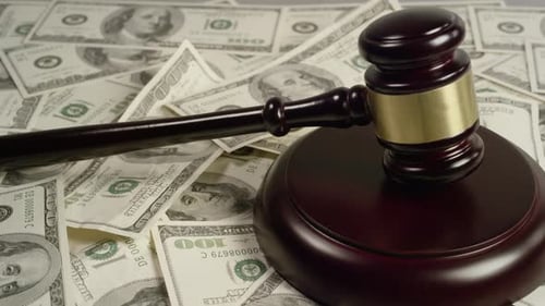 Judge's Gavel Resting on Pile of Hundred Dollar Bills