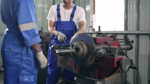 Diversity mechanic worker using metal lathe machine at the factory