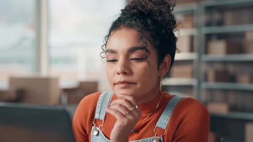 Young Woman Working on Laptop in Office or Warehouse