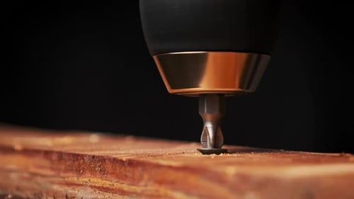 CloseUp of Unscrewing the Screw From a Block of Wood With a Screwdriver
