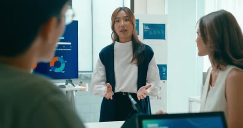 Group of Asian businesspeople work together leads business meeting uses presentation TV in office.