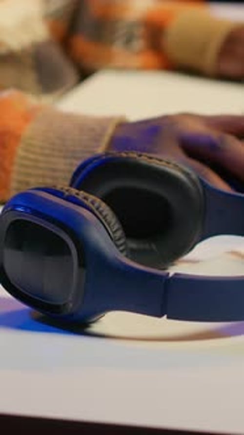 Man Putting On Headphones in Indoor Setting