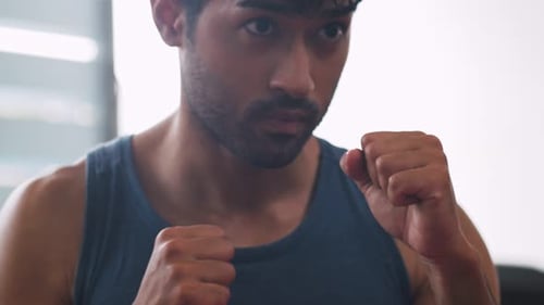 Young sporty man doing boxing training at the gym.