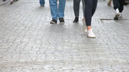 Concept crowd feet with shoes closeup. Anonymous people walking on the street. Legs of Crowd People