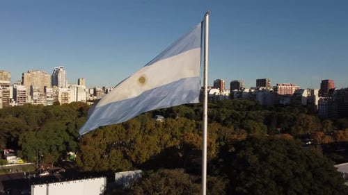 Argentinian Flag Waving Above City Park on Sunny Day