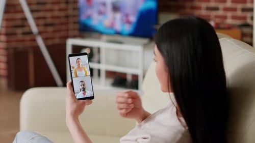 Asian Person Working Remotely From Home While Talking with Friends on Digital Videoconference Call