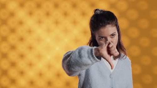 Disappointed Woman Bashing Book Showing Thumbs Down Sign Studio Background