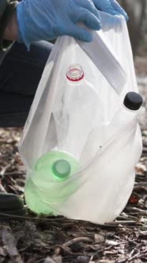 Ofrécete como voluntario limpiando la basura en la naturaleza para proteger el medio ambiente. Vídeo vertical.
