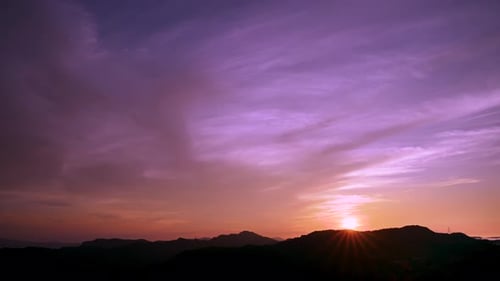 Paysage du lever du soleil au sommet de la montagne, avec des nuages colorés dans le ciel.