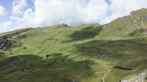 Aerial drone landscape of the meadows at high altitudes in the background. Dolomites, Alta Badia, Su