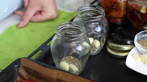 Filling Jars with Tomatoes, Garlic and Spices