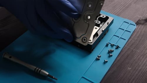 Mechaniker öffnet die Computerfestplatte zur Reparatur im Service Center