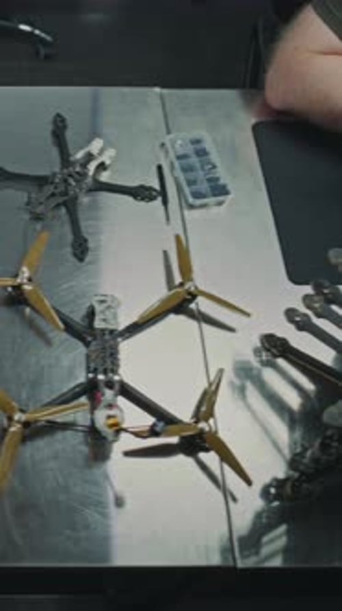 Technicians Carefully Assembly and Placing Finalized FPV Drone Into Box on Metal Workbench