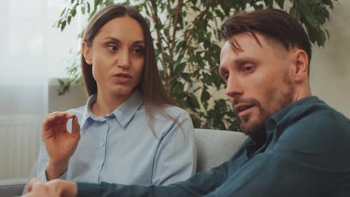 Couple Having Serious Discussion on Couch Indoors