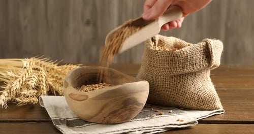 Wheat Grains Being Poured Into Wooden Bowl