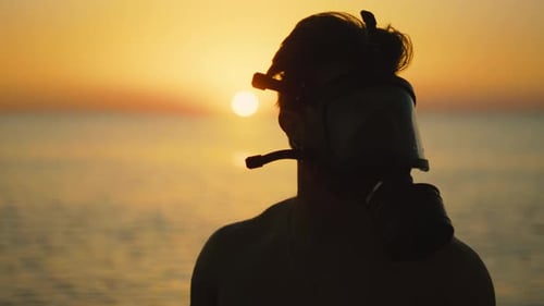 Homme au lever du soleil sur la plage avec masque à gaz