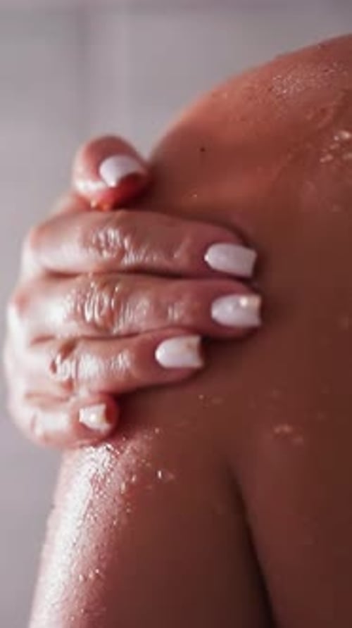 Woman's Arm Being Exfoliated in Shower