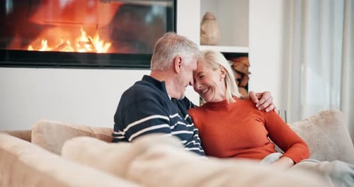 Mature Couple Embracing by Fireplace at Home