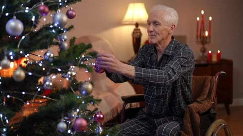 Senior Man Decorating Christmas Tree from Wheelchair