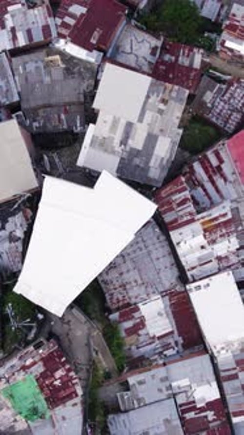 Aerial birds eye view of Comuna 13 showing colorful rooftops in Medellin, Colombia. Vertical video