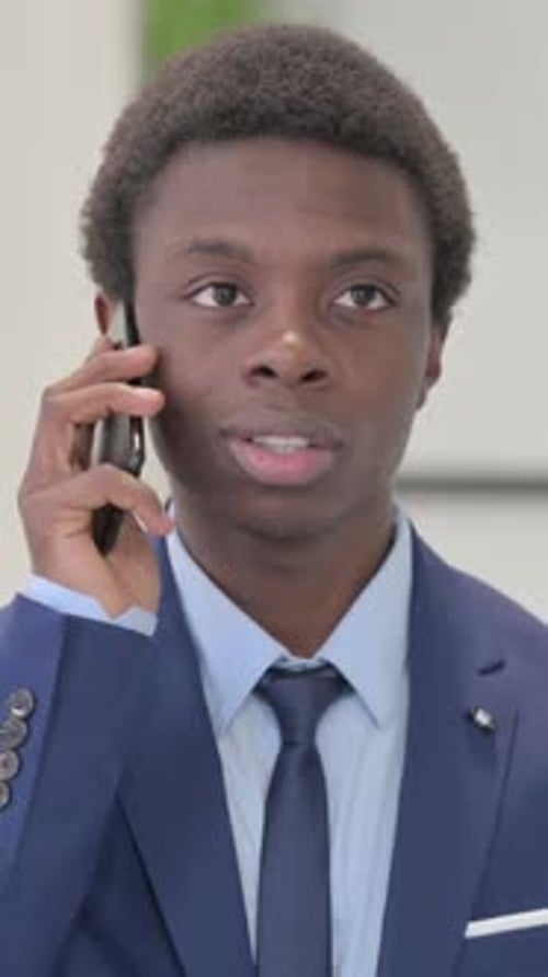 Young Man in Suit Talking on Mobile Phone