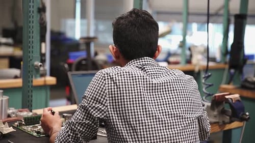 Man Works on Computer Component at Desk