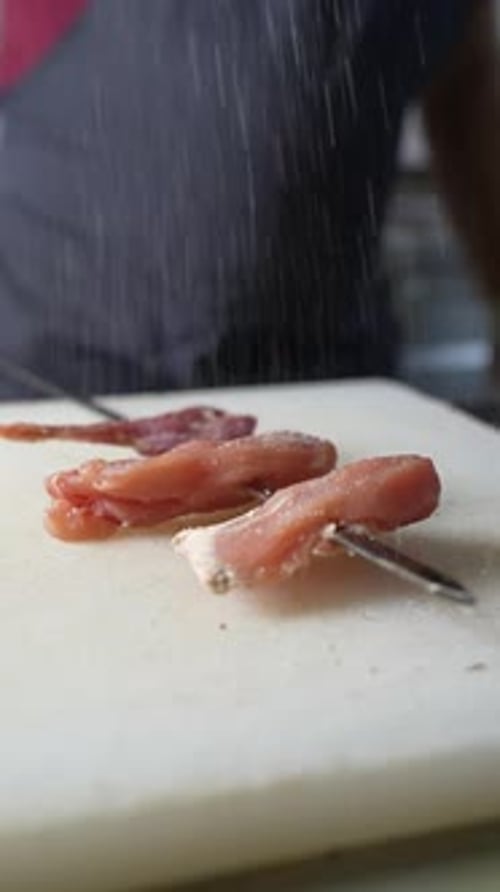 Seasoning Raw Poultry on White Cutting Board