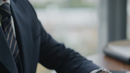 Seriöser Finanzanalyst tippt Berichte auf einem Laptop am Schreibtisch in der Nähe