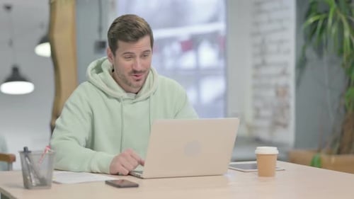 Young Man Doing Online Video Chat in Office