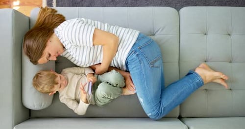 Woman and Child Relaxing on Gray Couch